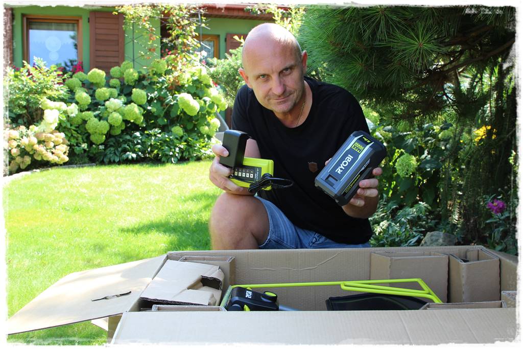 Trzymam ładowarkę i akumulator 5.0 Ah marki RYOBI Kosiarka akumulatorowa RYOBI 3